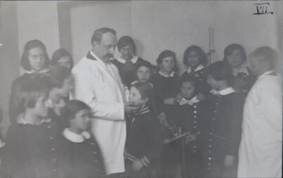 A group of young students standing around a teacher.